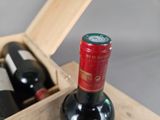 two bottles of wine in a wooden box on a table