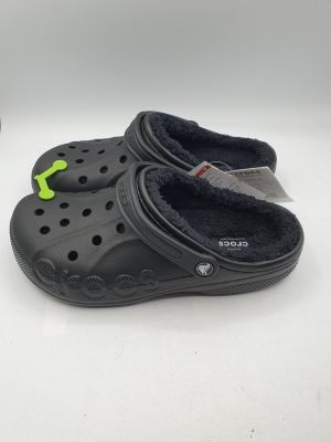 chaussons Crocs noirs avec un crochet vert sur le côté