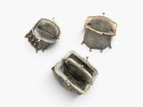 three pieces of silver metal mesh with a handle on a white surface