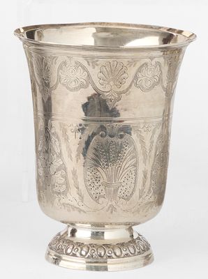 une tasse en argent antique avec un motif floral sur le bord