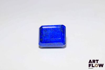 a close up of a blue square shaped stone on a white surface