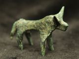 a small statue of a dog that is standing on the ground