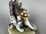 figurine of a man sitting on a bench with a dog on his lap