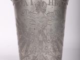 un vieux vase en argent orné d'un blason