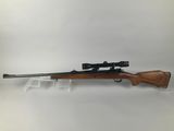 a rifle with a scope mounted on the side of it