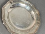 silver plate with scalloped edge on grey surface