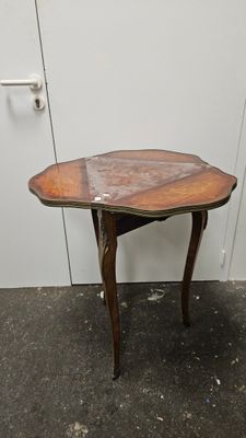 une petite table avec un plateau en bois posée sur le sol