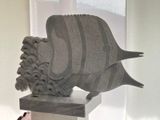 une statue représentant un poisson, posée sur un socle dans une pièce