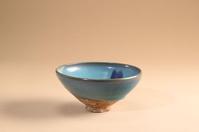 un petit bol bleu posé sur une surface blanche