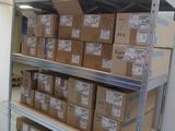 boxes are stacked on a shelf in a room with a blue bucket