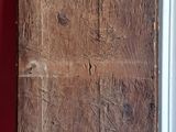a wooden door with writing on it next to a red wall