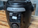 a black and silver air fryer sitting on a wooden table