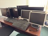 three computer monitors and a keyboard on a desk