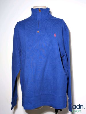 a blue sweater on a mannequin stand against a white wall