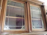 une grande armoire en bois avec deux portes vitrées et une étagère