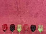 six verres à vin alignés sur une table en bois