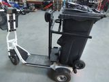a black and white scooter with a trash can on it