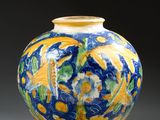 un vase bleu orné de motifs jaunes et verts