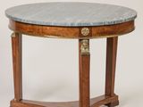 une table ronde avec un plateau en marbre et des pieds en bois