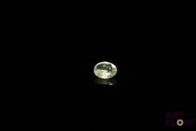 an image of a close up of a green gemstone on a black surface