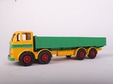 a green and yellow toy truck on a white surface