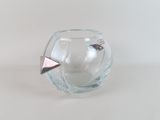 a small glass vase with a paper airplane inside of it