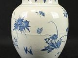 a blue and white vase sitting on a black surface