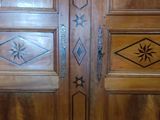 two wooden doors with decorative designs on them in a room