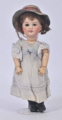 une poupée qui porte un chapeau et une robe