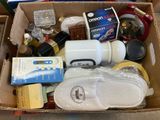 a cardboard box filled with items that include shoes, soap, toothbrushes, and other items