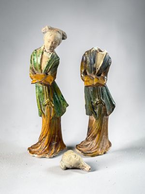 pair of chinese figurines of a woman and a man with a dog