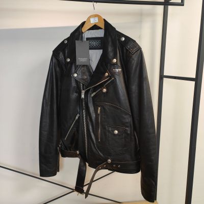 une veste en cuir noir suspendue à un portant dans un magasin de vêtements