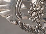 a close up of a silver plate with flowers on it