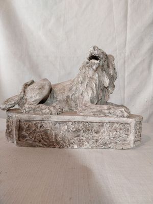 une statue représentant un lion assis sur une table
