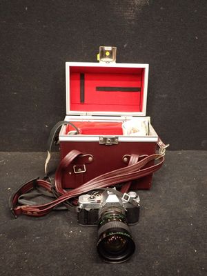un étui rouge contenant un appareil photo et une courroie d'appareil photo