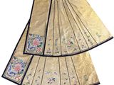 two pieces of gold cloth with blue trims and flowers on them