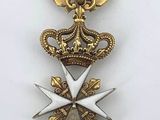 an image of a gold and white medal with a crown on it