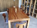 a wooden table and chairs in a room with shelves