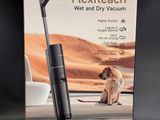 le carton d'un aspirateur, avec un chien assis par terre