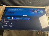 television with remote control and remote control screen sitting on a table