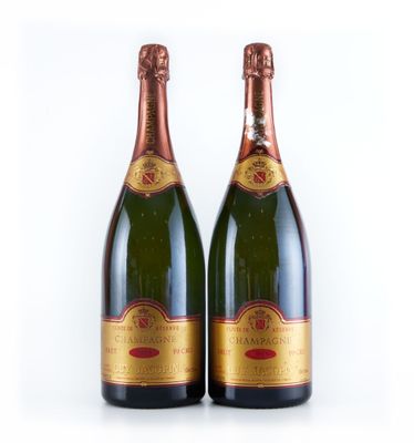 deux bouteilles de champagne posées l'une à côté de l'autre sur une surface blanche