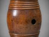 an old wooden vase with a hole in the middle of it