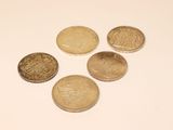 several coins are arranged in a triangle on a white surface