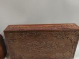 pair of wooden boxes with carved designs on them sitting on a white surface