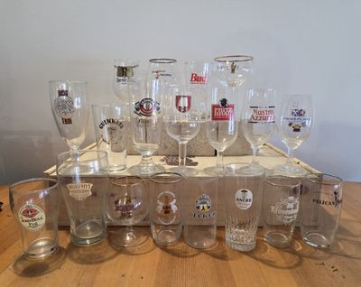 bottles and glasses are lined up on a wooden tray on a table