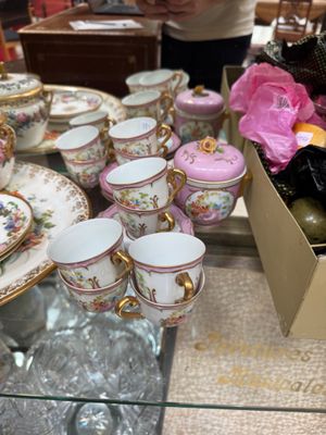 many cups and saucers sitting on a glass table