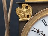a gold clock with a bird on top of it