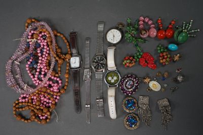 de nombreux bijoux posés sur une table, parmi lesquels une montre et un bracelet