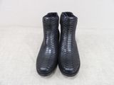 a pair of black boots on a white surface