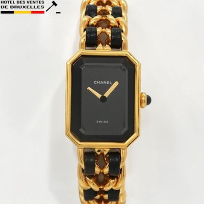 une montre noire et dorée, entourée d'une chaîne